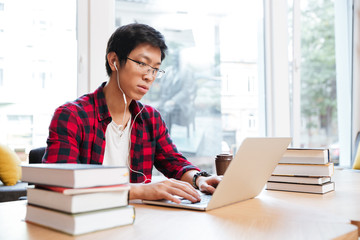 Man listen to music while writing using laptop