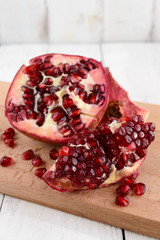 Ripe garnet have broken into pieces on a white background. Juicy Asian fruit. Close up.