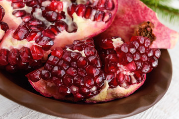 Ripe garnet have broken into pieces on a white background. Juicy Asian fruit. Close up.