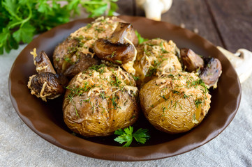 Baked potatoes with mushrooms, cheese and herbs on dark wooden background. Close up.