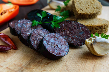Morcillo (Spanish black pudding, blood sausage), cutting slices, black rye bread in a heart shape,...
