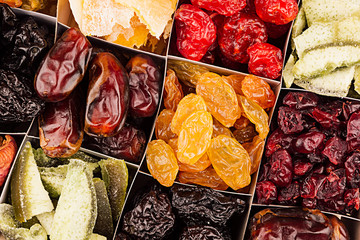 Assortment of dried fruits closeup background in square cells. Decorative pattern of dry exotic fruit. Top view.