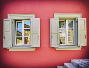 two grey windows on colorful fuchsia house wall, filtered