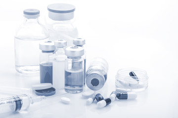 Glass Medicine Vials with syringe pills capsule on white table