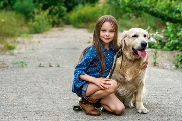 Little girl playing with her big dog outdoors in rural areas 