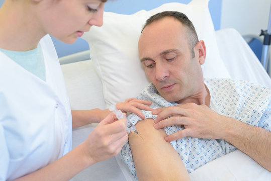 a nurse inoculating a middle-aged man