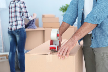 House moving concept. Closeup of man packing cardboard box