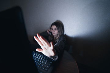 teenager girl sitting at the computer at night. It is a victim of excessive harassment and bullying...