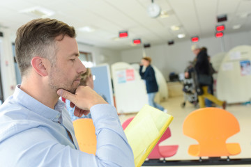 man reading documents while sitting in modern office space interior