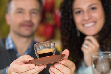 Couple holding forward an expresso