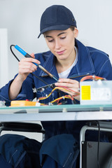 female technician working on an electronic circuit