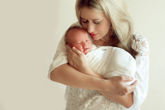 Beautiful Russian woman, a young mother holding a wrapped newbor