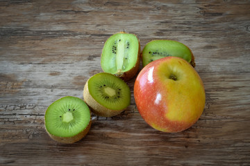 Apple and kiwi isolated on rustic black background. Organic food.