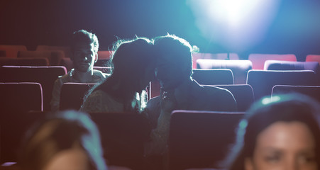 Young loving couple kissing at the cinema