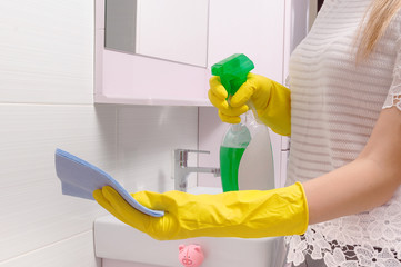 Female hands cleaning mirror with green cloth. Spring clean up
