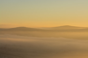 Fototapeta na wymiar Sunrise over Dartmoor with Tors in view like sand dunes, Devon, UK