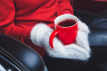 girl in red sweater and white mittens holding cup