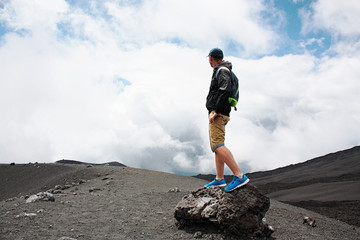 Encouraged man on the hill is looking on Etna volcano eruption. Etna, Italy © opolja