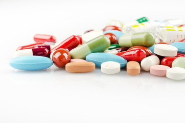 Pharmacy theme. Multicolored Isolated Pills and Capsules on the White Surface. Closeup