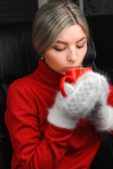 girl in red sweater white mittens holding cup and drinks