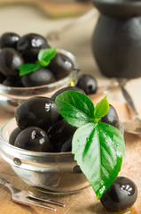 Black olives in oil on a wooden background