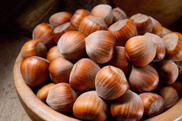 Hazelnut. Fresh organic filbert in wooden plate on dark backgrou