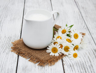 jug with milk  and chamomile flower