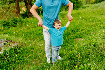 Happy dad with his little son in summer park