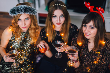 Three girls looking at camera at a home party