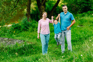 Fototapeta premium happy family walking in the park playing