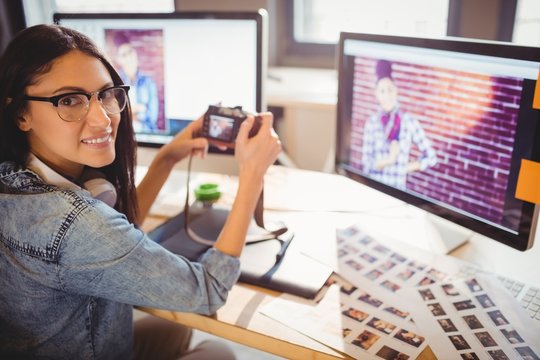 Graphic designer looking at pictures in digital camera