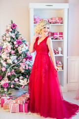 Fototapeta premium young beautiful woman in evening dress at Christmas tree