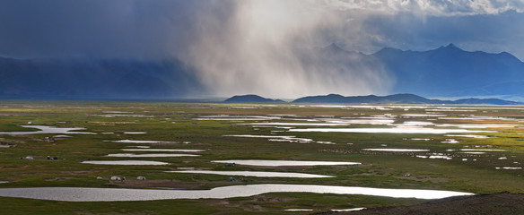 Panorama of Tibetan plateau at sunset with an approaching storm