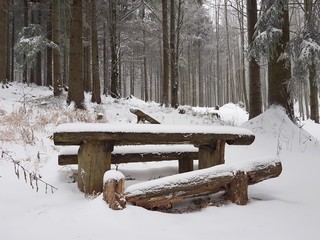 Stara drewniana ława przy górskim szlaku zima