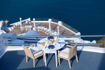 Balcony with breakfast in Firostefani, Santorini at sunrise