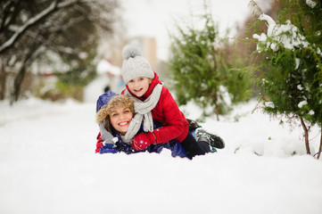 Young woman with daughter of school age lie having embraced on snow.