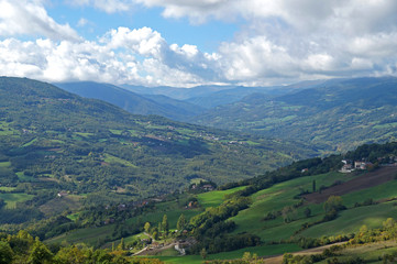 Fototapeta premium Rural landscape panorama with a meadow , hills on the horizon and curved path