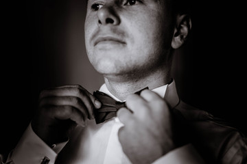 Fototapeta na wymiar handsome groom getting dressed and preparing for the wedding