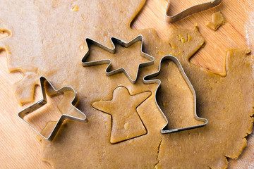 Cookies forms and gingerbread dough on wooden pastry board