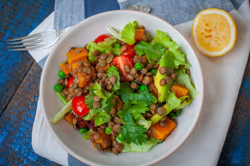 Salad with baked sweet potatoes, avocados, lentils, dried tomatoes, cilantro, pumpkin seeds and...