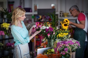 Florists spraying water on flowers in flower shop