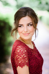 young and beautiful woman in red dress standing in the park