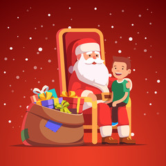 Santa Claus holding little smiling boy on his lap