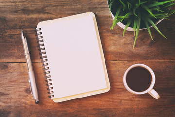 open notebook with blank pages next to cup of coffee