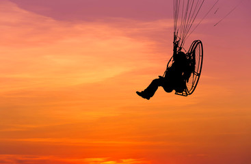 paraglider flying  with paramotor on sunset © Soonthorn