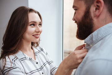 Loving couple standing near window together