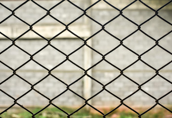 Rusty steel chain link or wire mesh as boundary wall. There is still concrete block wall behind the mesh.Best security.