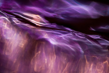 Abstract background with light waves in violet tones in futurist