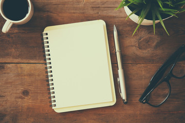 open notebook with blank pages next to cup of coffee
