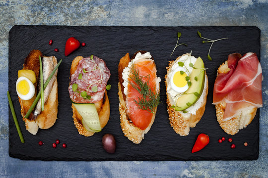 Mini Sandwiches Food Set. Brushetta Or Authentic Traditional Spanish Tapas For Lunch Table. Delicious Snack, Appetizer, Antipasti On Party Or Picnic Time. Top View.